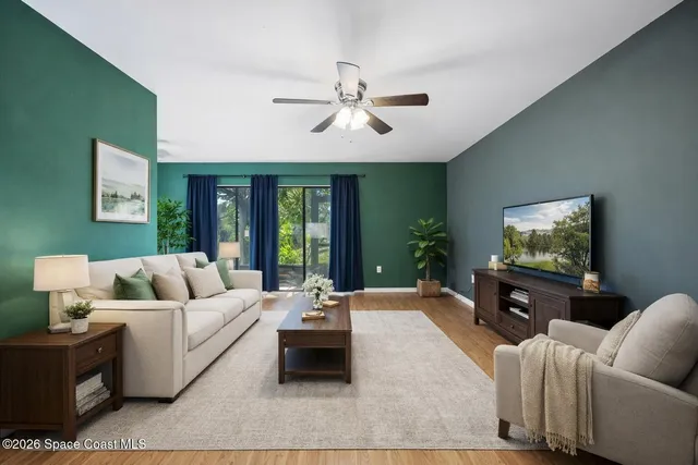 a view of a big room with windows and ceiling fan