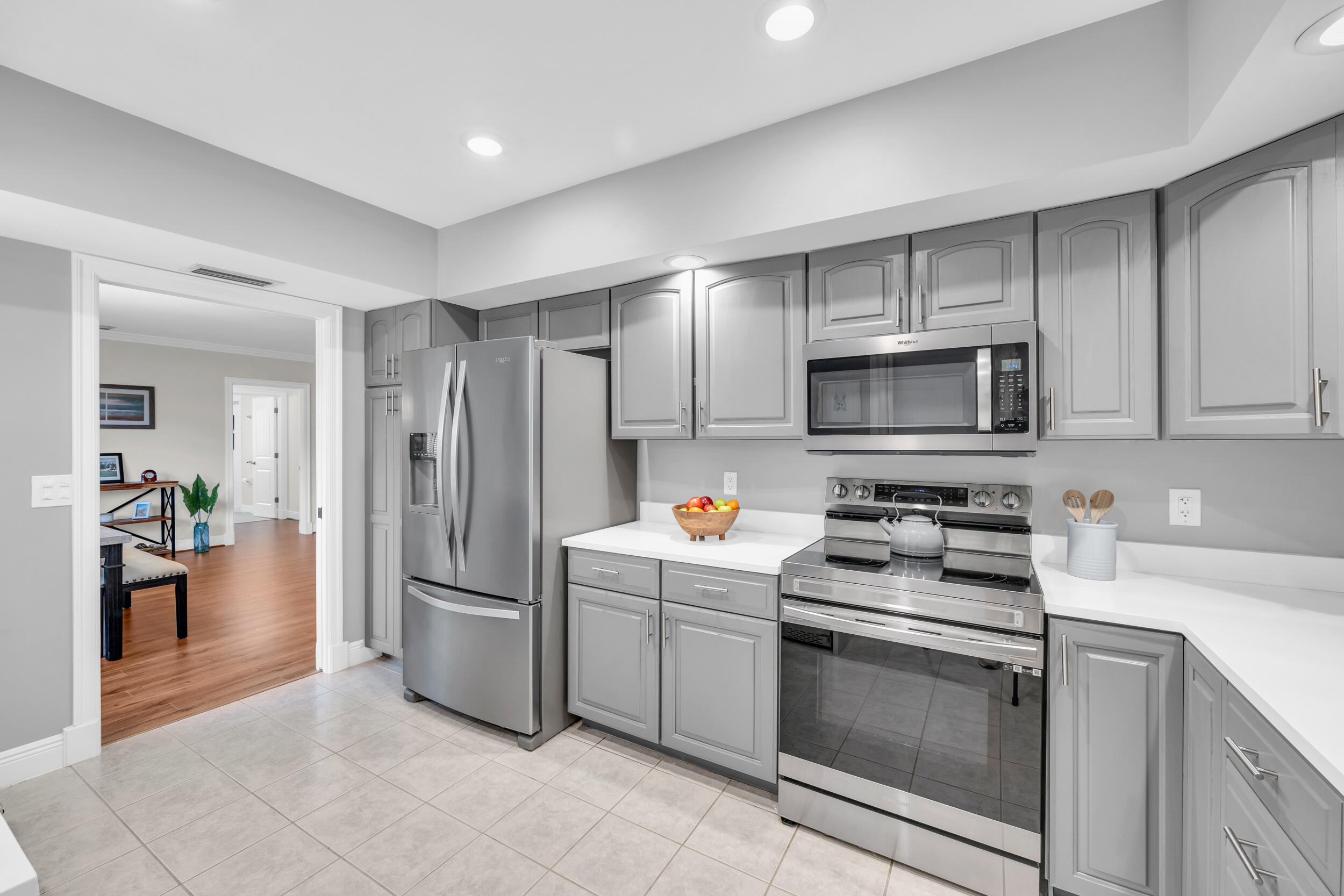 8 Southeast Turtle Creek Drive, Unit D Jupiter, FL 33469 - Photo 11 of 33 a kitchen with stainless steel appliances a refrigerator stove microwave and sink
