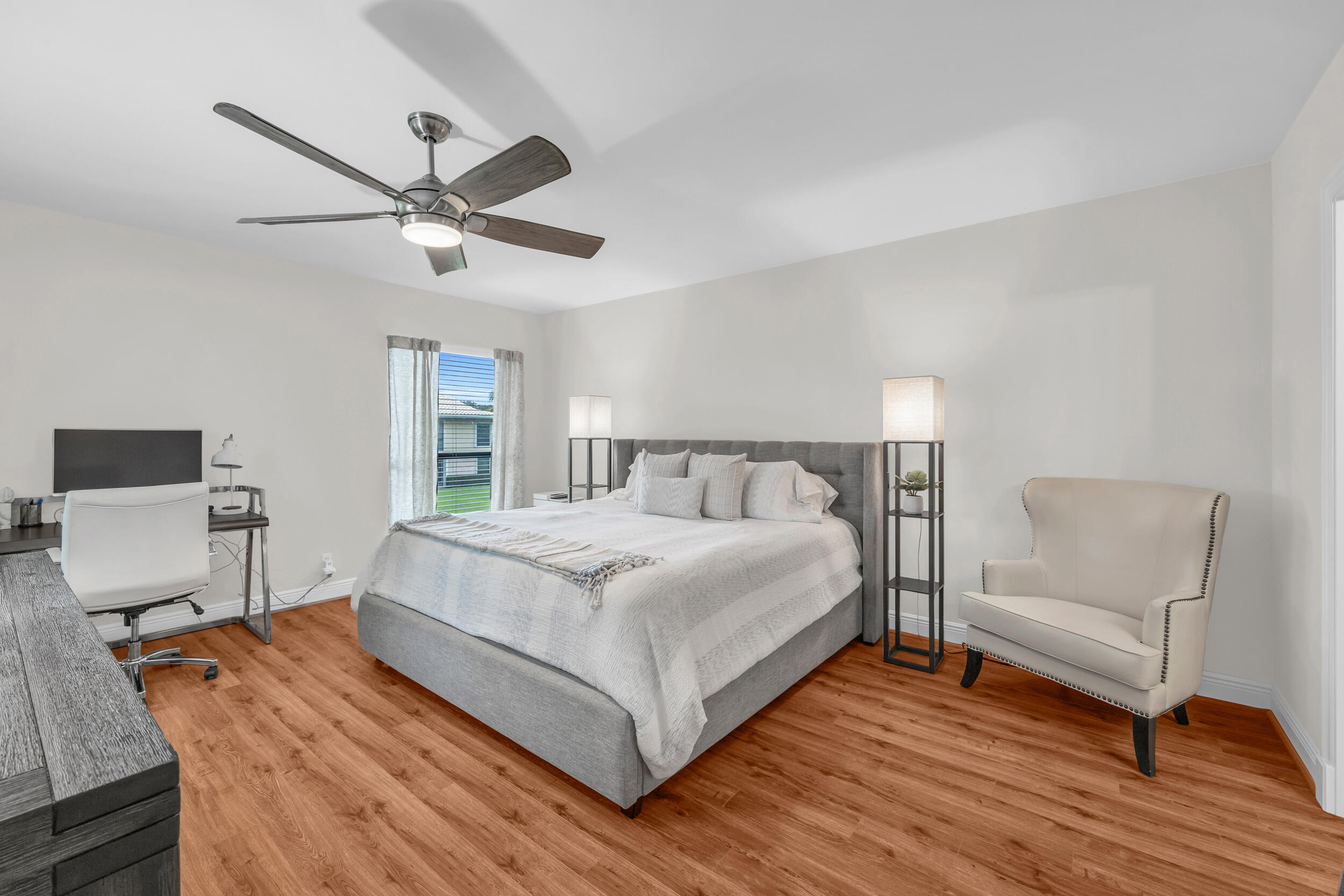 8 Southeast Turtle Creek Drive, Unit D Jupiter, FL 33469 - Photo 12 of 33 a bedroom with a bed and wooden floor