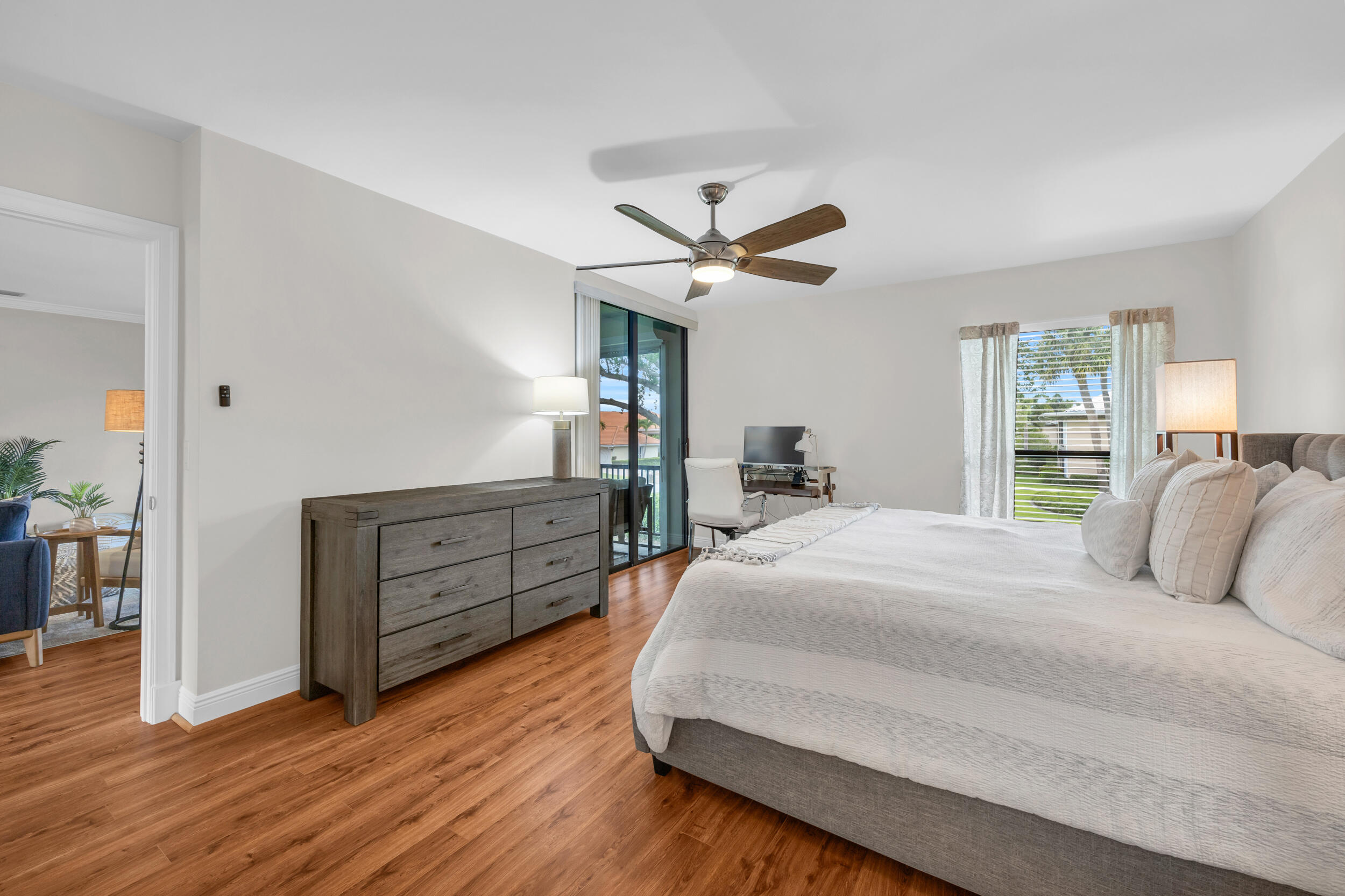 8 Southeast Turtle Creek Drive, Unit D Jupiter, FL 33469 - Photo 13 of 33 a bedroom with a bed and wooden floor
