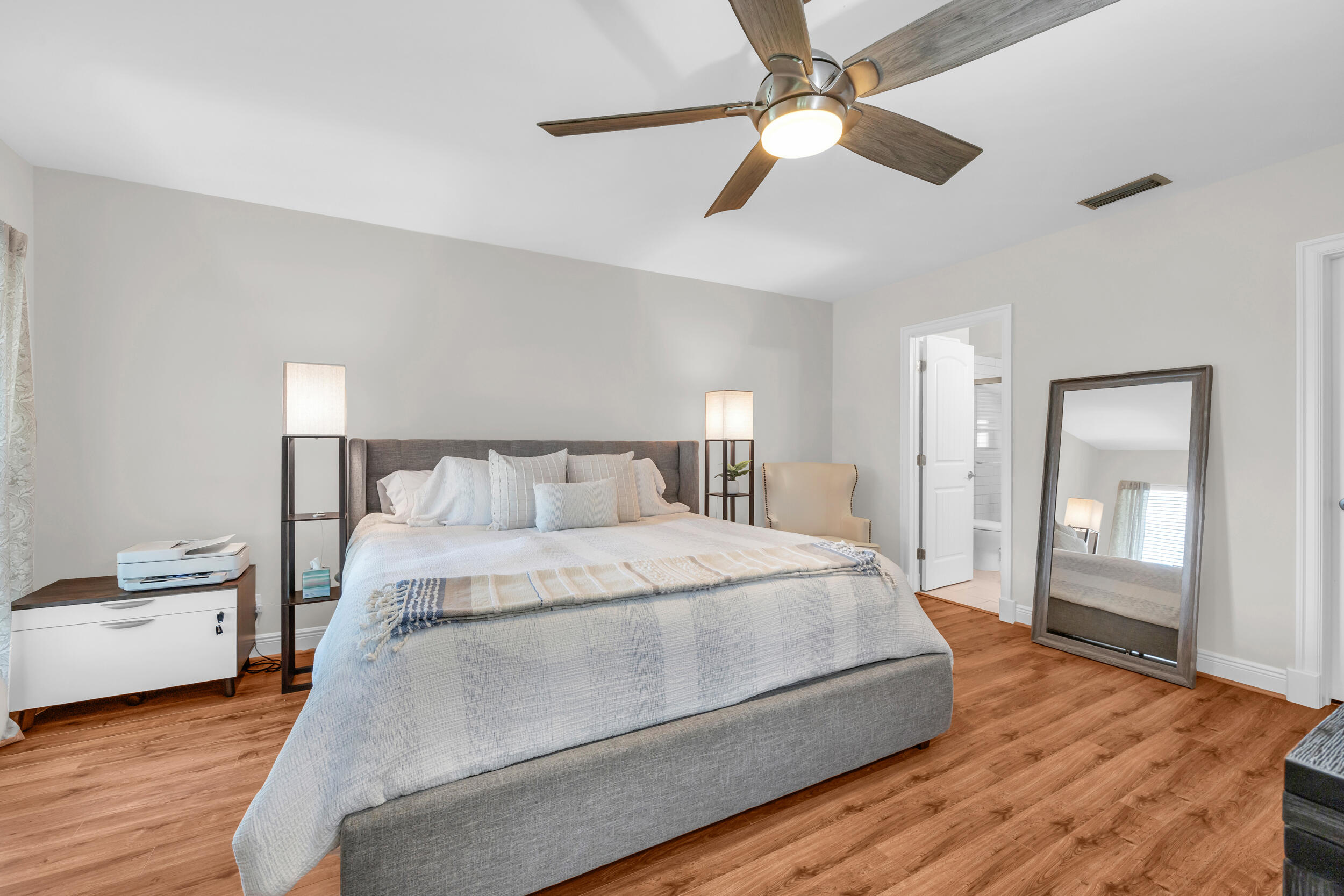 8 Southeast Turtle Creek Drive, Unit D Jupiter, FL 33469 - Photo 14 of 33 a bedroom with a bed and a chandelier