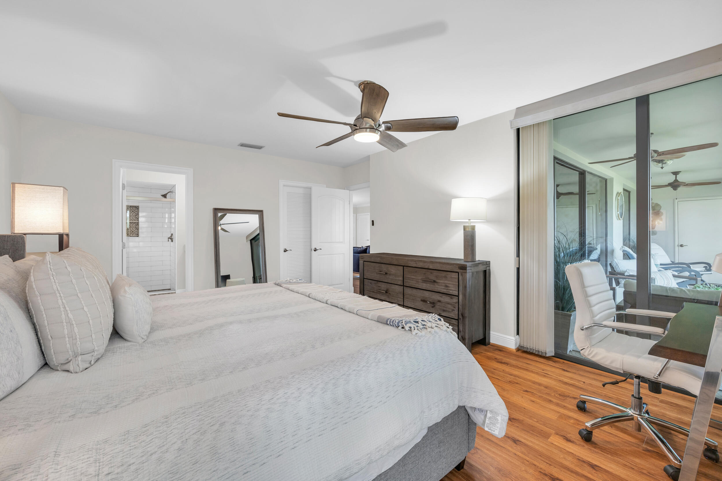 8 Southeast Turtle Creek Drive, Unit D Jupiter, FL 33469 - Photo 15 of 33 a bedroom with a bed and a chandelier