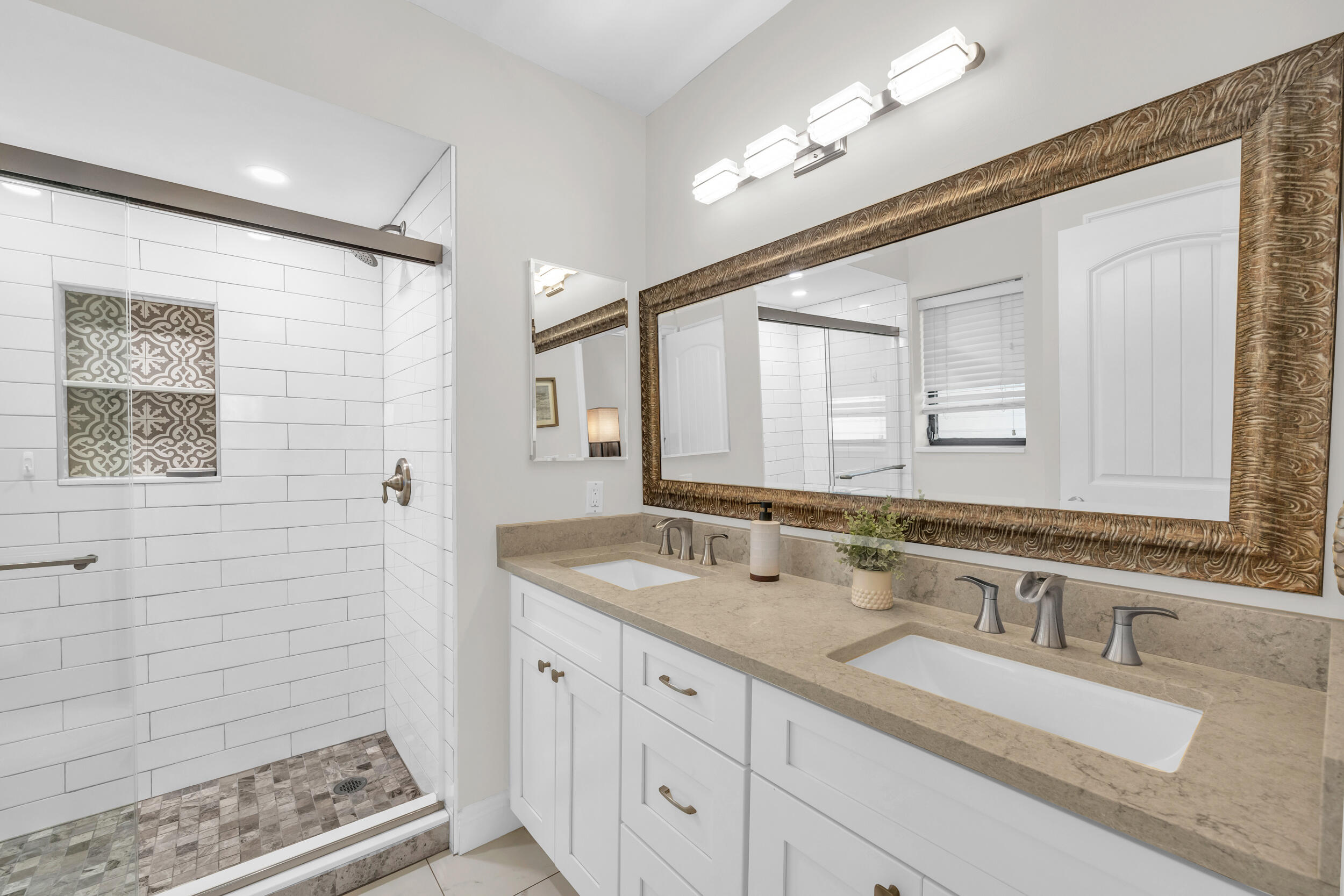 8 Southeast Turtle Creek Drive, Unit D Jupiter, FL 33469 - Photo 16 of 33 a bathroom with a granite countertop double vanity sink a mirror and a shower