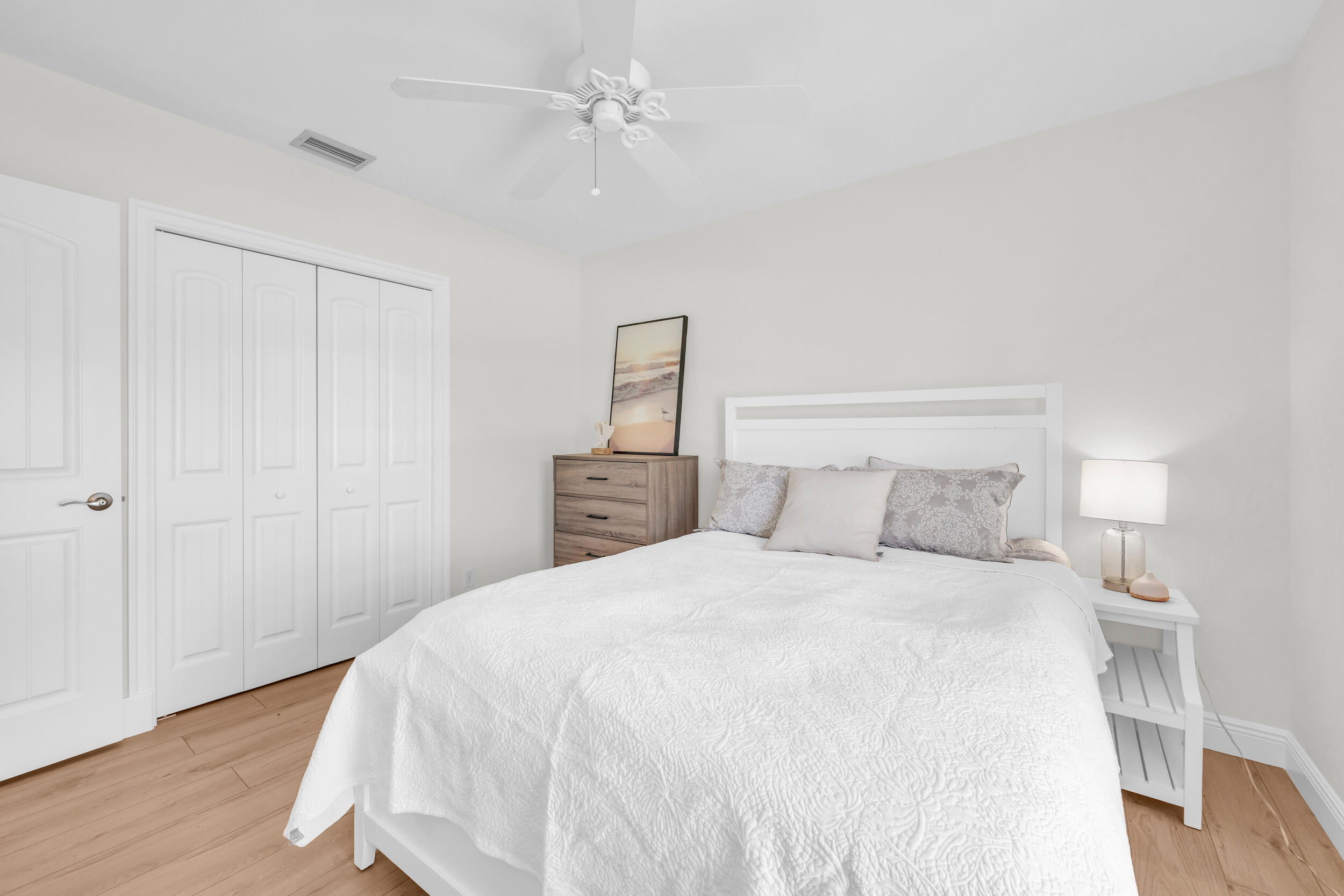 8 Southeast Turtle Creek Drive, Unit D Jupiter, FL 33469 - Photo 20 of 33 a bedroom with a bed and a ceiling fan