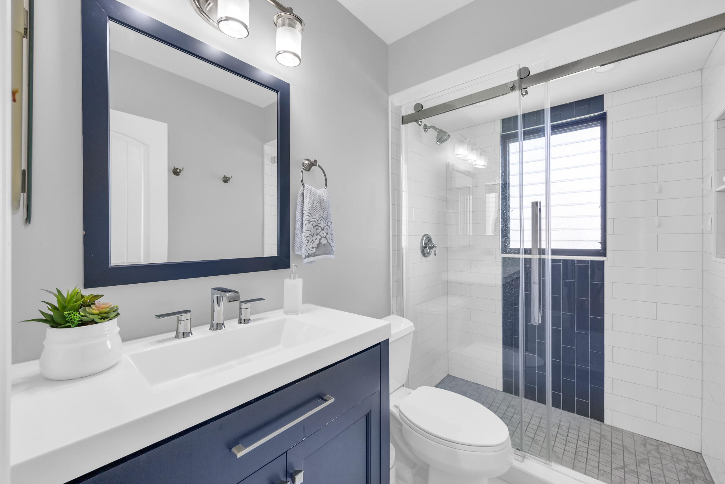 8 Southeast Turtle Creek Drive, Unit D Jupiter, FL 33469 - Photo 21 of 33 a bathroom with a sink a toilet a shower and a mirror