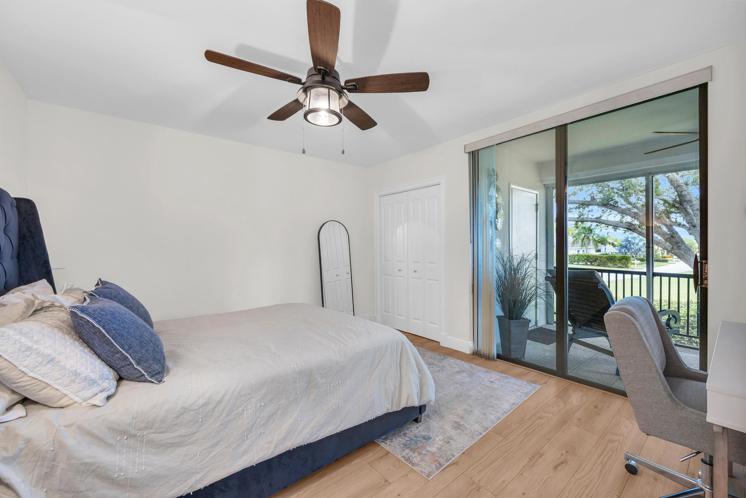 8 Southeast Turtle Creek Drive, Unit D Jupiter, FL 33469 - Photo 22 of 33 a bedroom with a bed and a chandelier