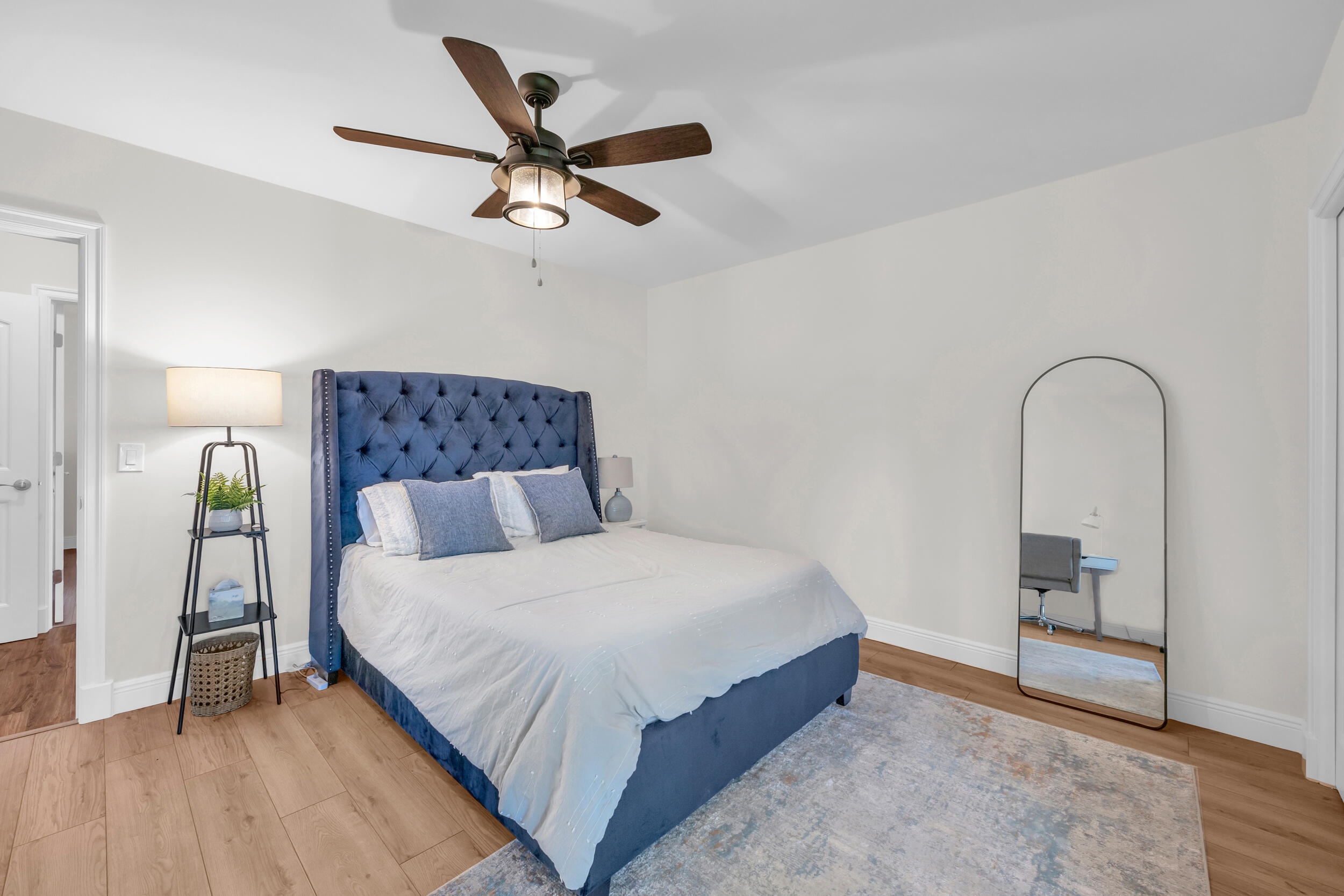 8 Southeast Turtle Creek Drive, Unit D Jupiter, FL 33469 - Photo 23 of 33 a bedroom with a large bed and a chandelier