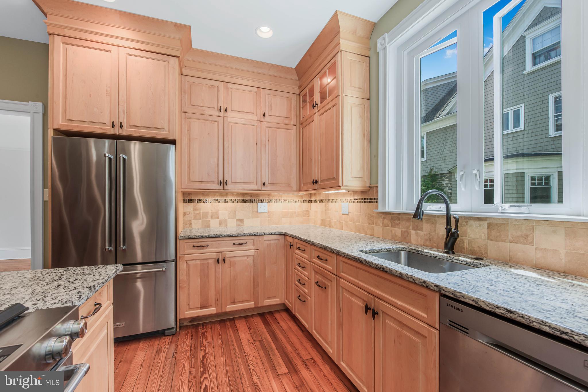 14 Simpson Road Ardmore, PA 19003 - Photo 22 of 58 a kitchen with stainless steel appliances granite countertop a refrigerator a sink and white cabinets with wooden floor