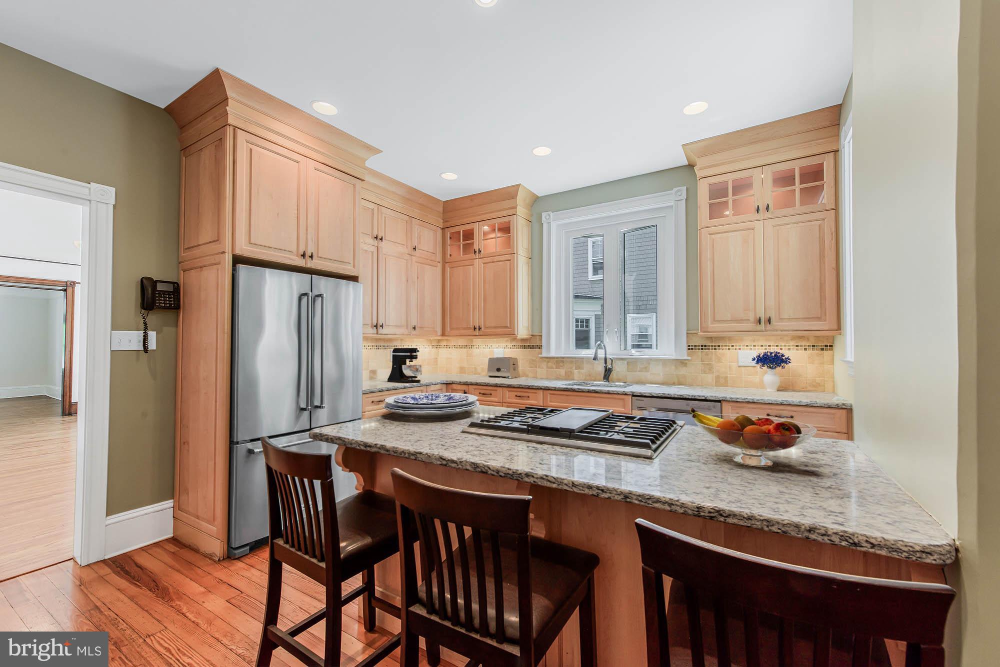 14 Simpson Road Ardmore, PA 19003 - Photo 24 of 58 a kitchen with granite countertop a table chairs stove and refrigerator