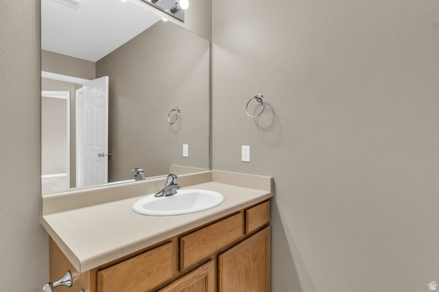 656 South 910 West, Unit 25 Pleasant Grove, UT 84062 - Photo 19 of 25 Bathroom vanity featuring wood-finish cabinetry and a neutral-toned countertop with an integrated sink.