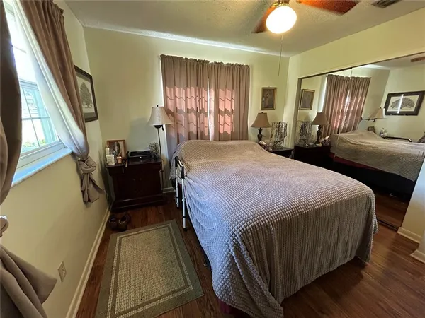 a bedroom with a bed and wooden floor
