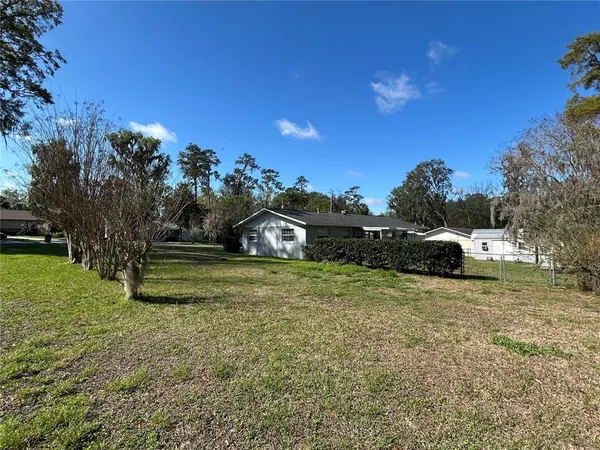 a front view of a house with a garden and trees