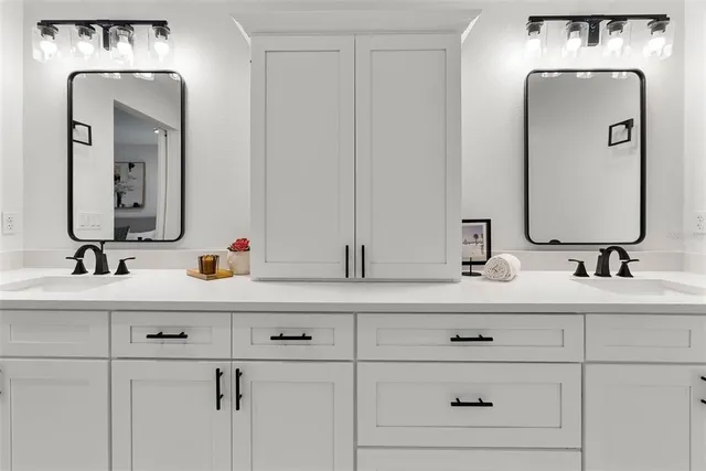 a bathroom with double vanity sinks and a mirror