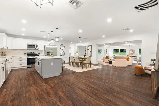 a living room with lots of furniture and kitchen view
