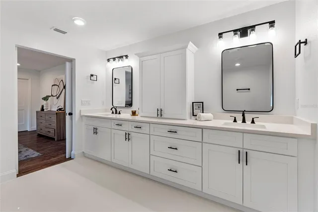 a bathroom with double vanity sinks and a mirror