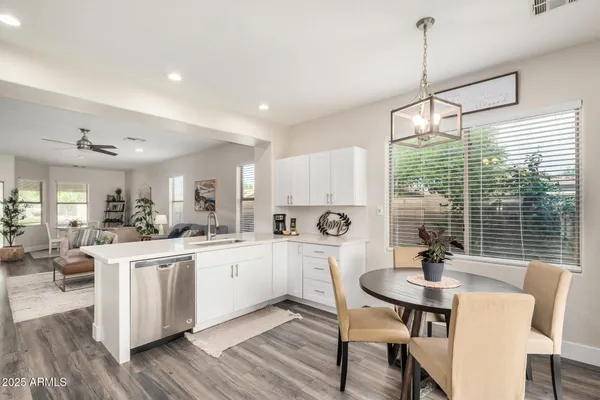 a kitchen with white cabinets and chairs