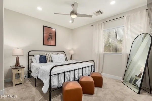 a bedroom with a bed a couch and a chandelier