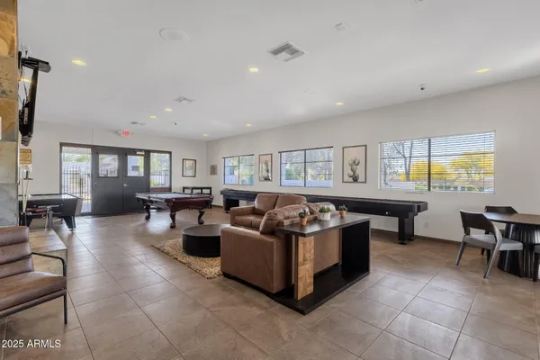 a living room with pool table and windows