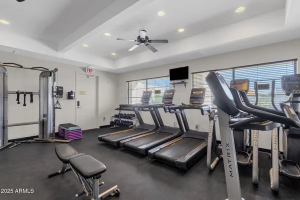 a view of swimming pool with seating space and trees in the background