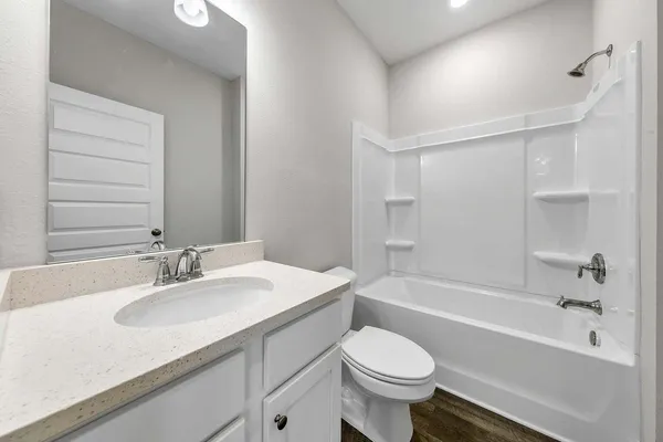 a bathroom with a sink toilet vanity and bathtub