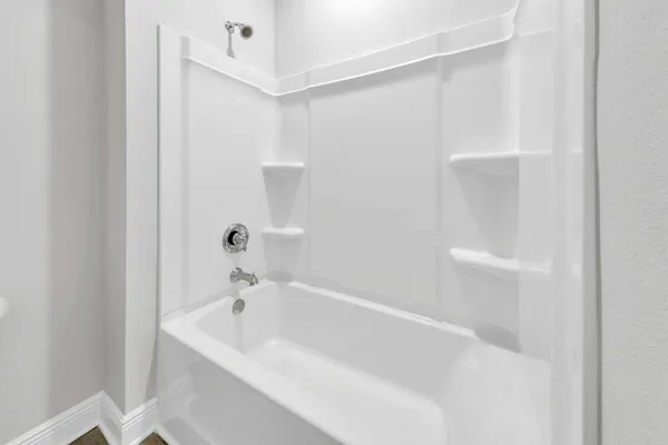 a white bath tub sitting next to a white sink