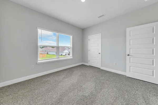 an empty room with windows and closet