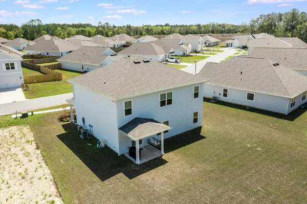 an aerial view of a house with a yard swimming pool and outdoor seating