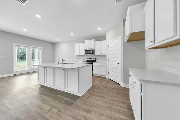 a kitchen with granite countertop white cabinets and stainless steel appliances