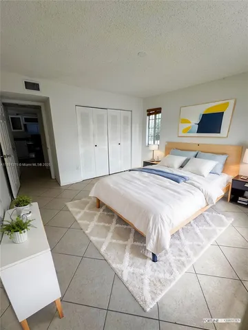 a bedroom with a bed a rug and a window