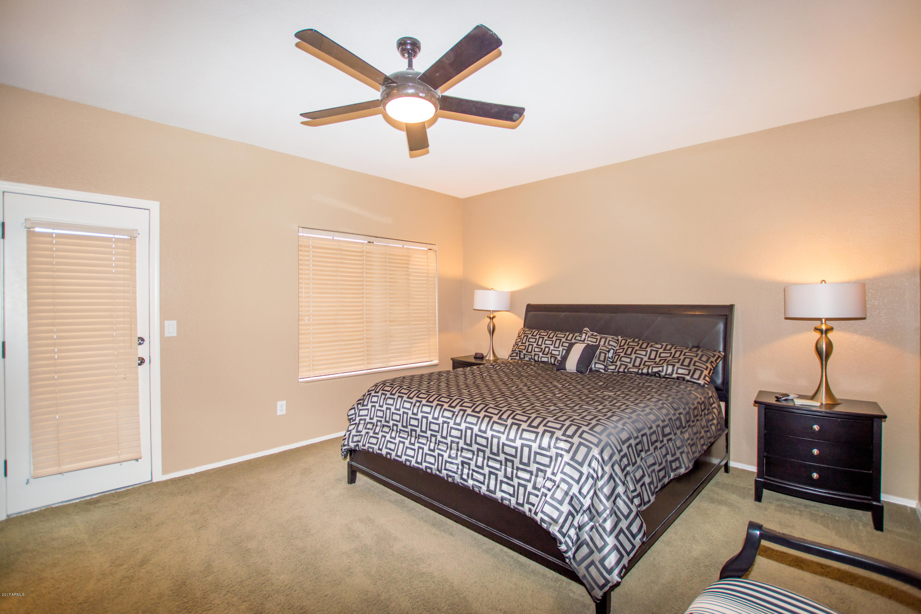 3150 East Beardsley Road, Unit 1016 Phoenix, AZ 85050 - Photo 9 of 25 a bedroom with a bed a dresser and a chandelier