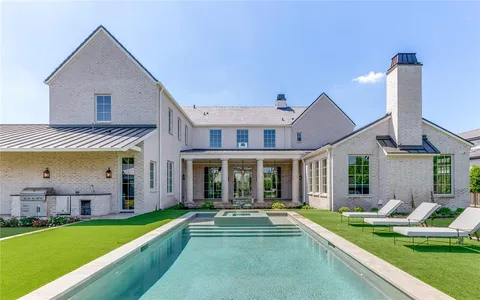 a view of house with a big yard and swimming pool