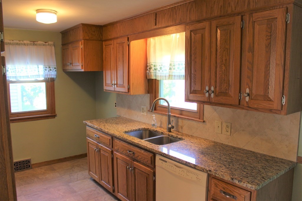 32 Randall Street Chicopee, MA 01013 - Photo 4 of 28 a kitchen with stainless steel appliances granite countertop a sink a stove and a microwave