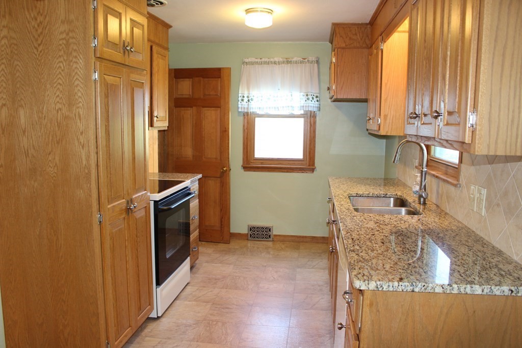 32 Randall Street Chicopee, MA 01013 - Photo 5 of 28 a bathroom with a granite countertop sink a washer and dryer