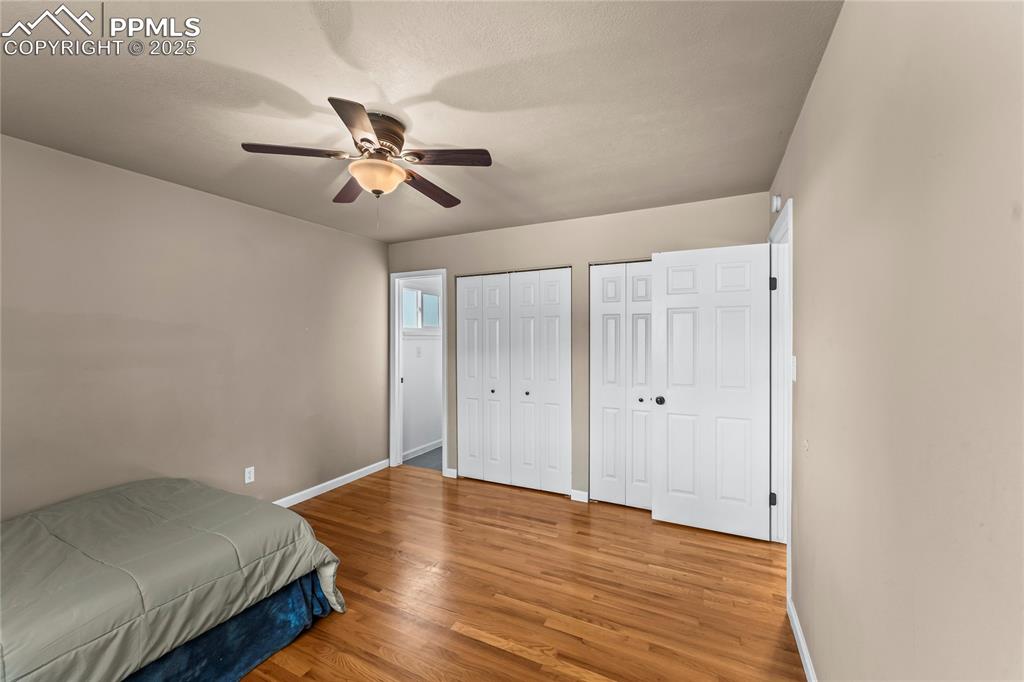 526 Griffith Way Colorado Springs, CO 80911 - Photo 19 of 46 a bedroom with wooden floor and a ceiling fan