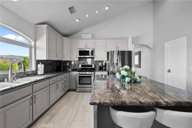 a kitchen with stainless steel appliances granite countertop a stove oven and a refrigerator