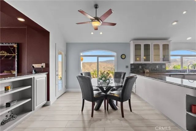 a kitchen with a table chairs refrigerator and microwave