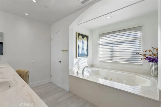 a spacious bathroom with a bathtub shower sink and mirror