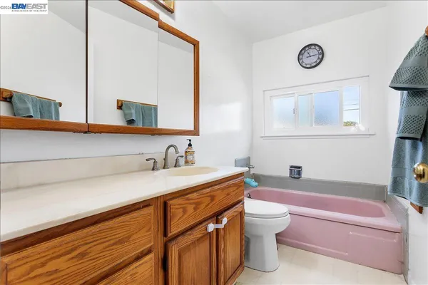 a bathroom with a granite countertop sink mirror vanity and toilet