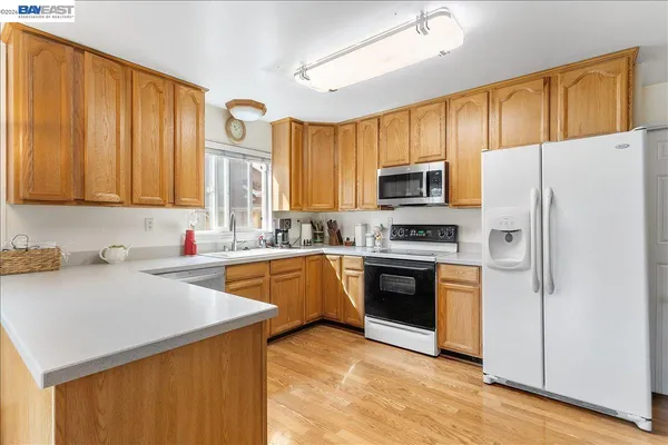 a kitchen with stainless steel appliances granite countertop a refrigerator stove microwave and sink