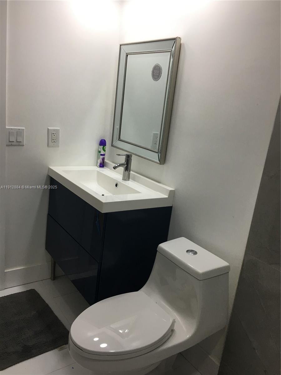 Boca del Mar Boca Raton, FL 33433 - Photo 5 of 6 a bathroom with a toilet sink and mirror