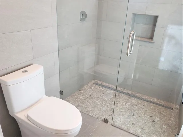 a bathroom with a toilet and a shower