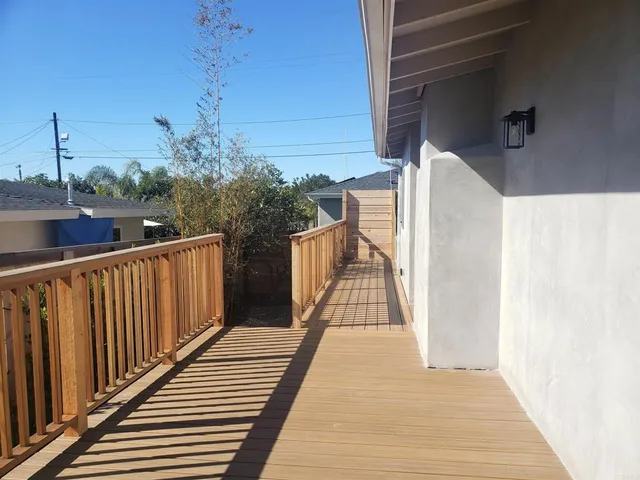 a view of balcony with wooden floor and fence