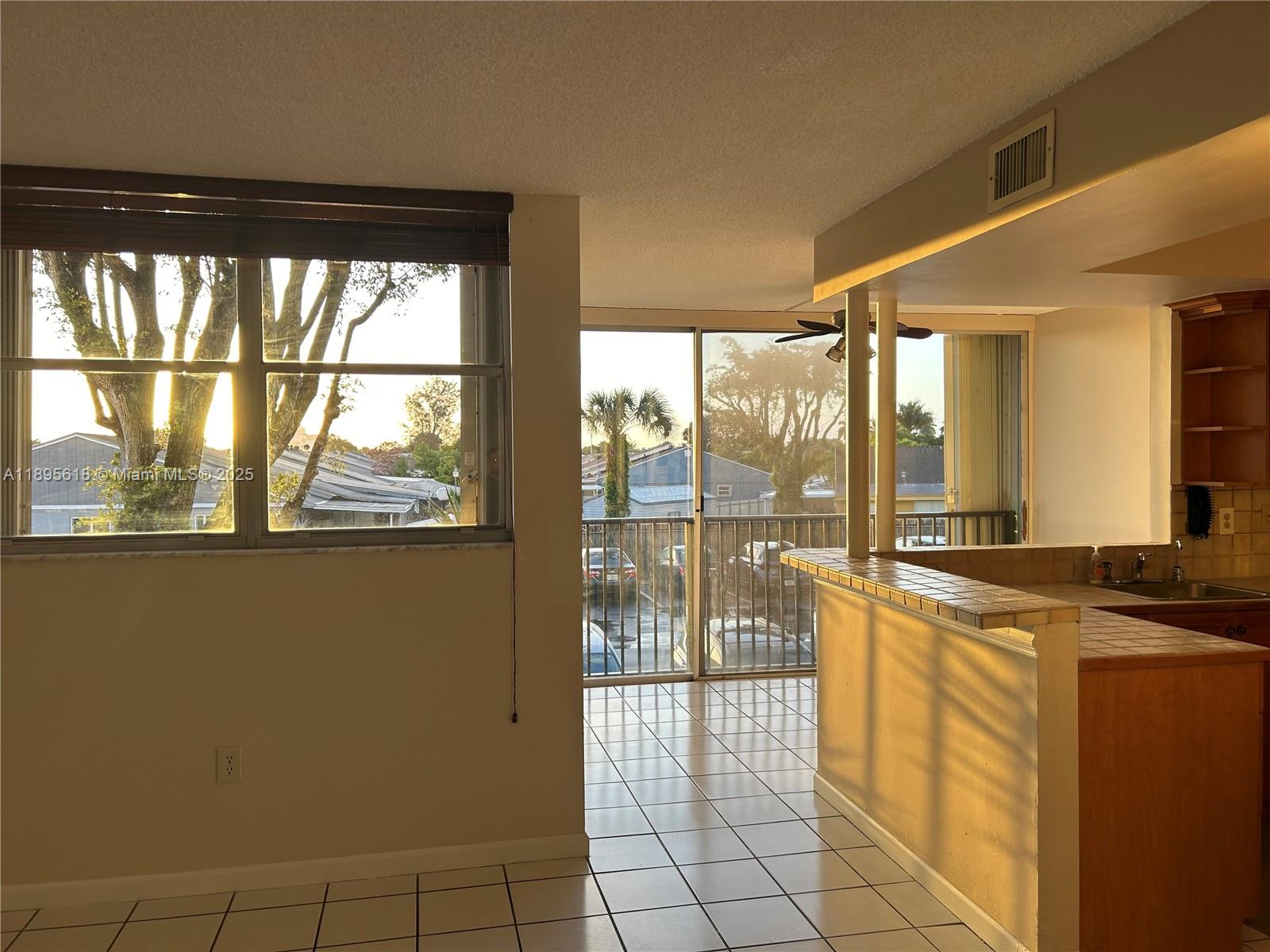 9411 Southwest 4th Street, Unit 202 Miami, FL 33174 - Photo 17 of 20 a view of a kitchen with furniture and large windows