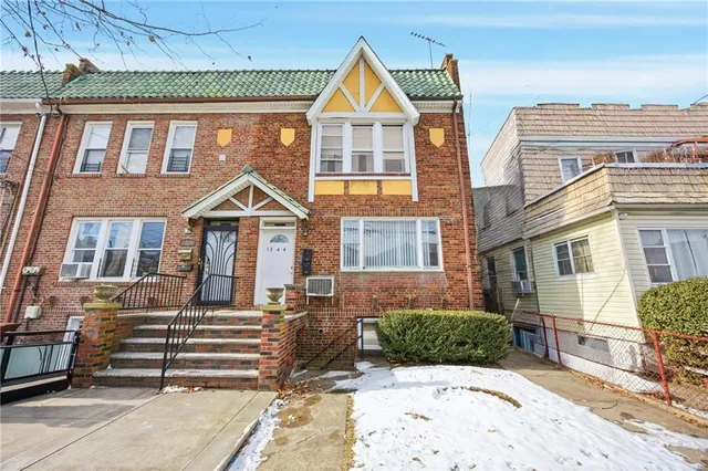 a view of a brick house with many windows and a yard