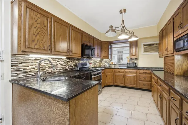 a kitchen with granite countertop a sink stainless steel appliances and cabinets