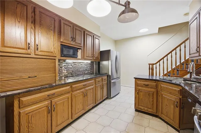 a kitchen with stainless steel appliances granite countertop a sink and cabinets