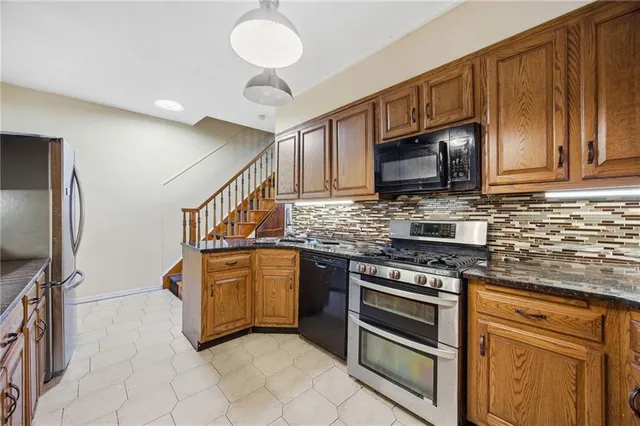 a kitchen with stainless steel appliances granite countertop a stove microwave and cabinets