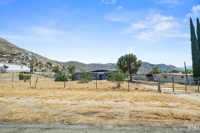 a view of a backyard with a wooden fence