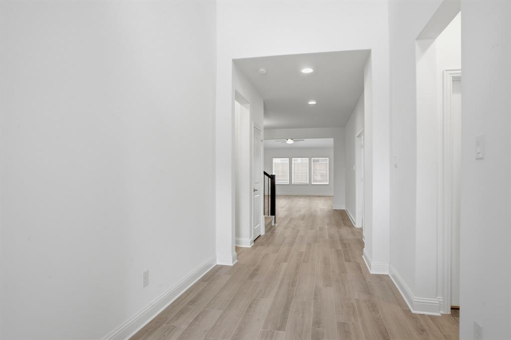 2911 Hanscom Street Forney, TX 75126 - Photo 2 of 40 Hallway with recessed lighting, wood-finish flooring, white baseboards, and bright white walls
