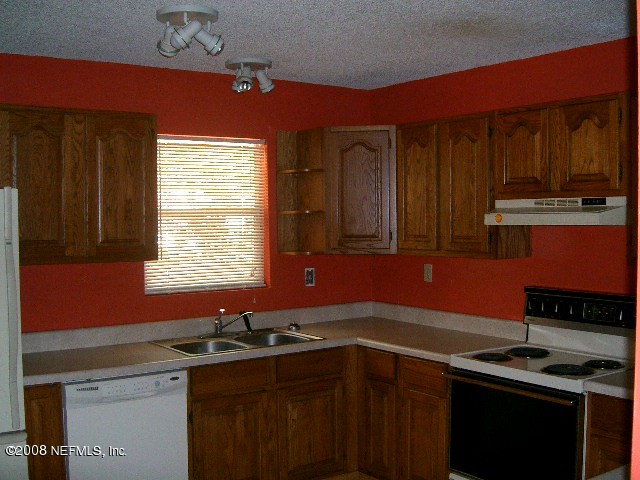 144 Katnack Road St. Augustine, FL 32095 - Photo 7 of 7 a kitchen with stainless steel appliances a sink stove and cabinets